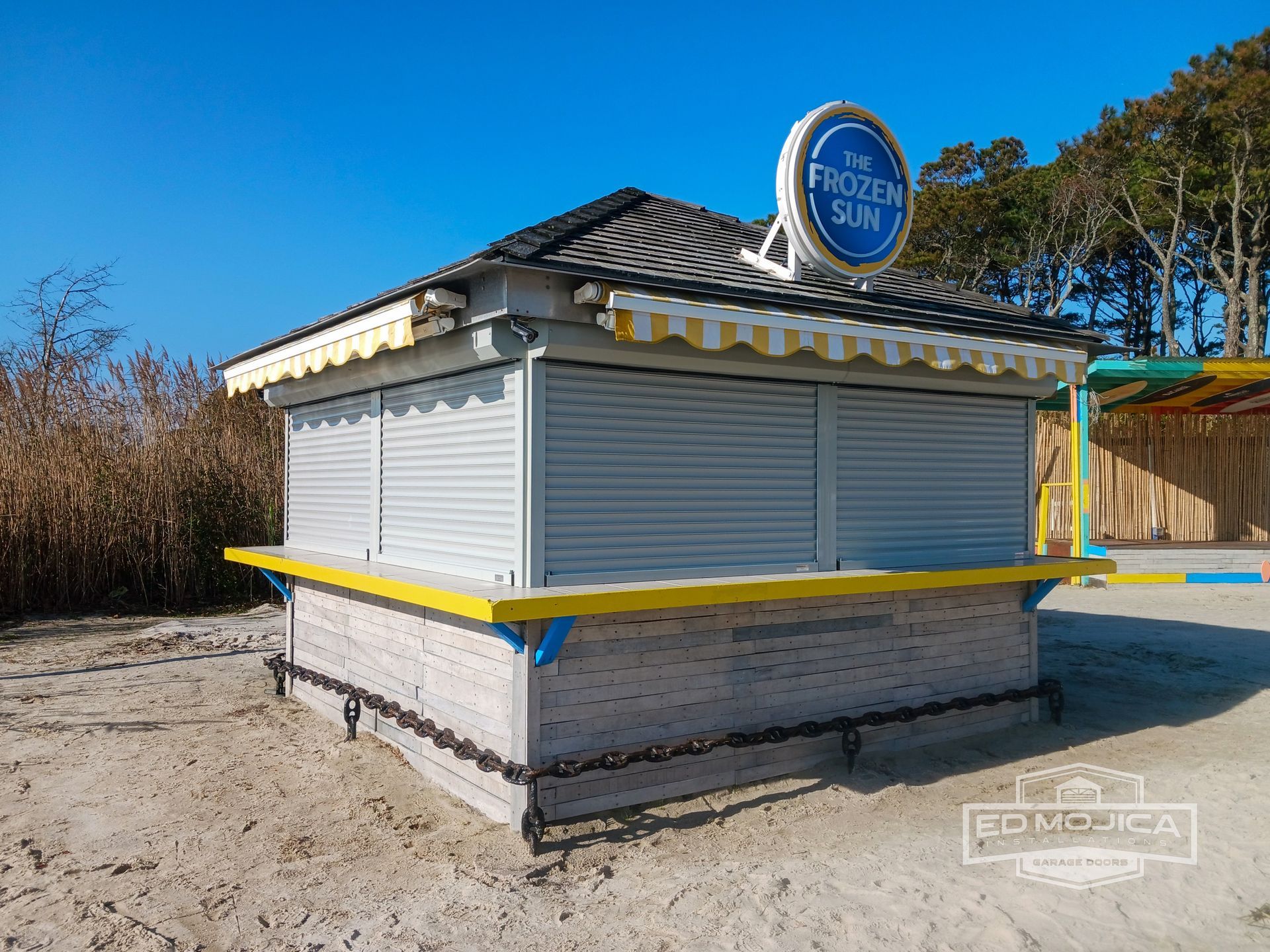 A small stall with shutters on the windows is on the beach