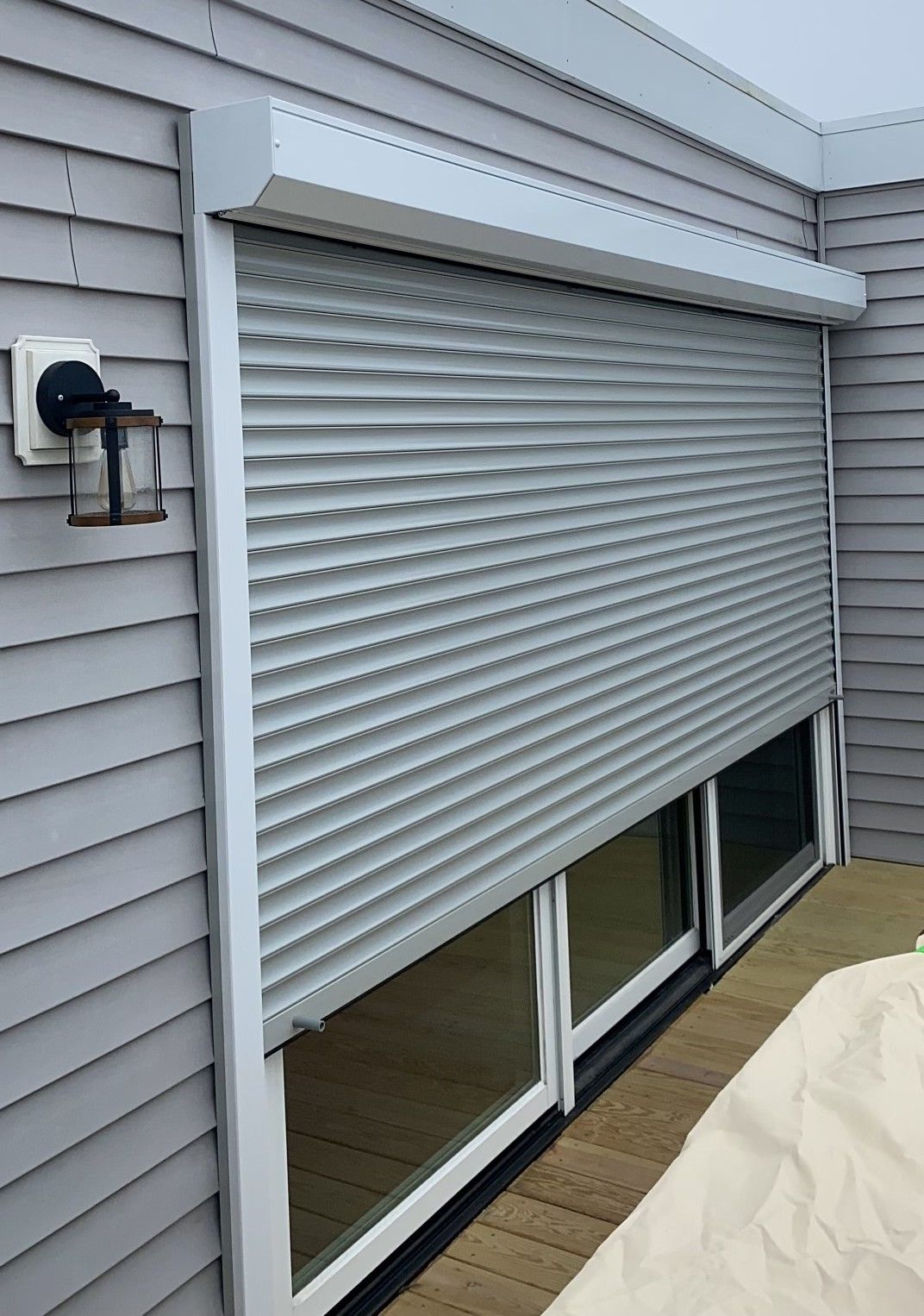A house with a sliding glass door with a roller shutter on it.