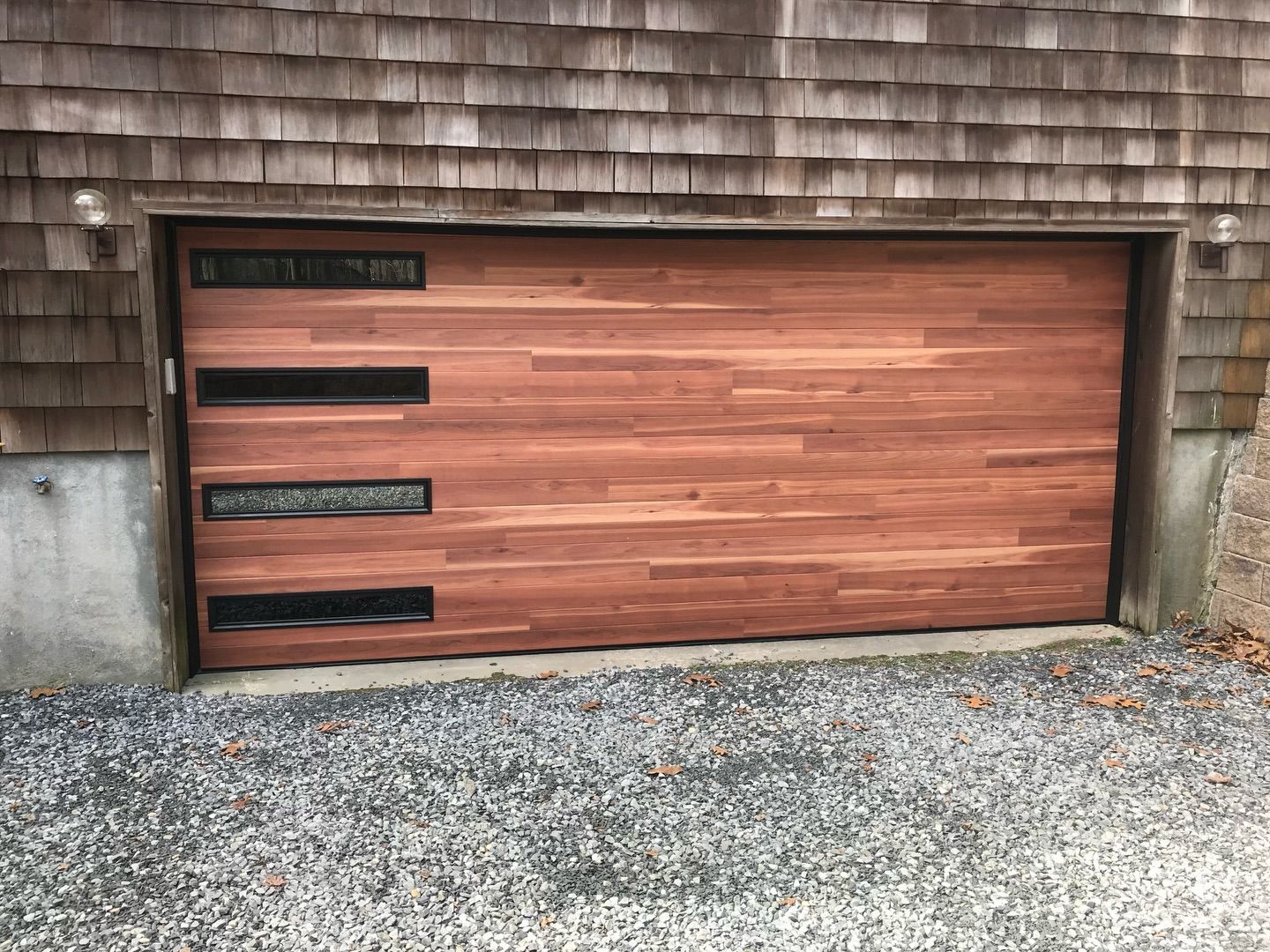 A wooden garage door is sitting in front of a house.