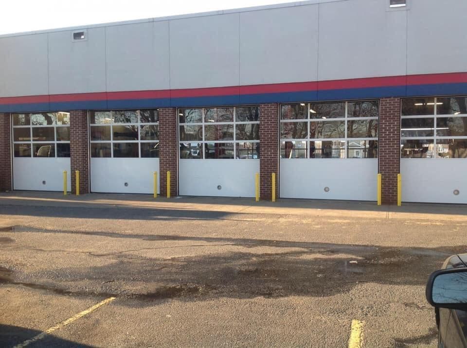 A car is parked in front of a building with a lot of garage doors