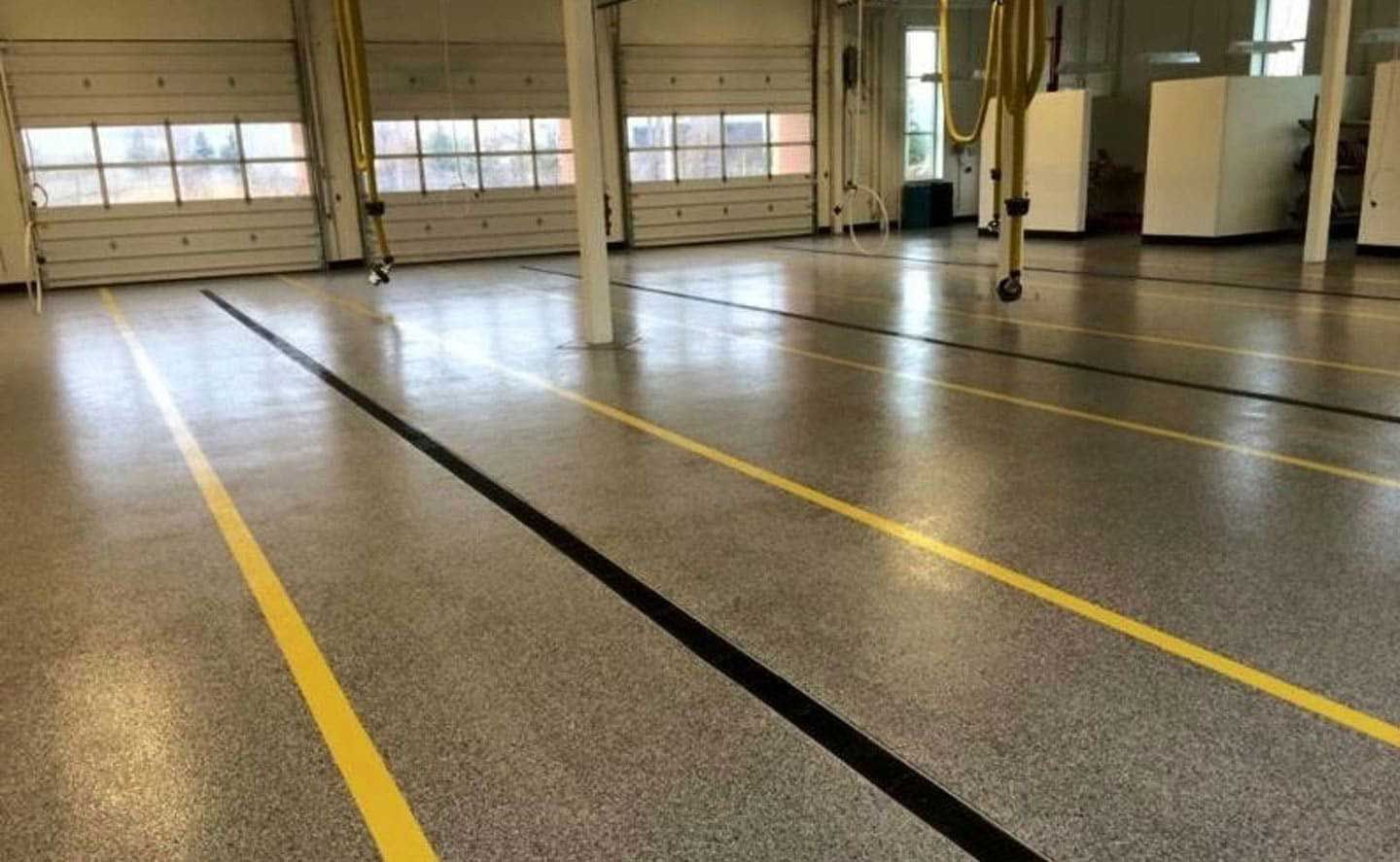 A large empty garage with a yellow line on the floor.