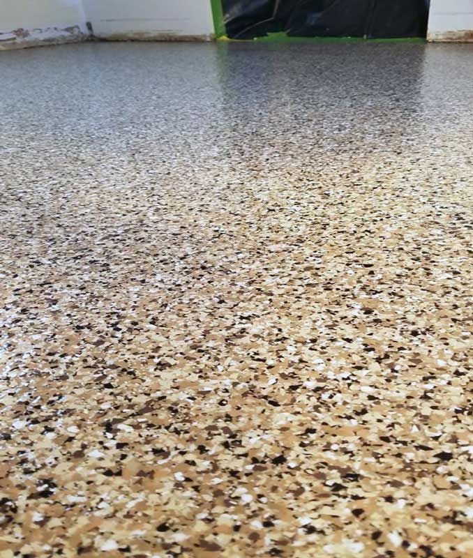A close up of a concrete floor with a lot of small stones on it.