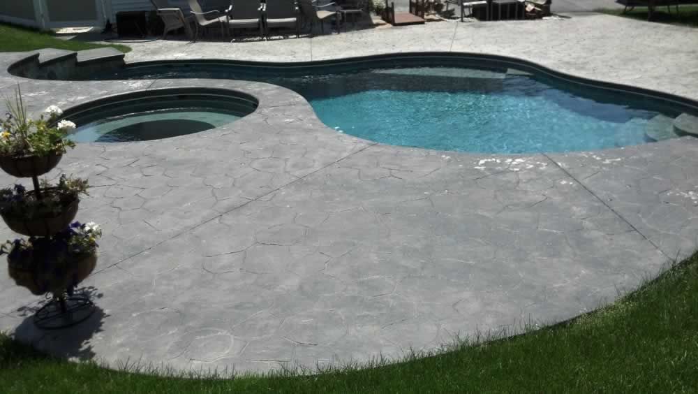 A large swimming pool with a hot tub in the middle of it.