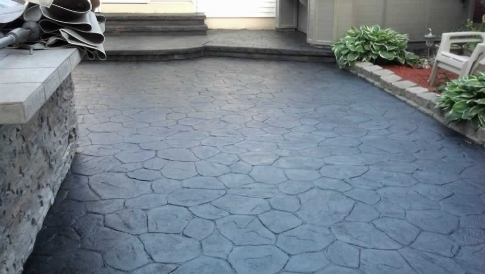 A patio with a concrete floor and a bench.