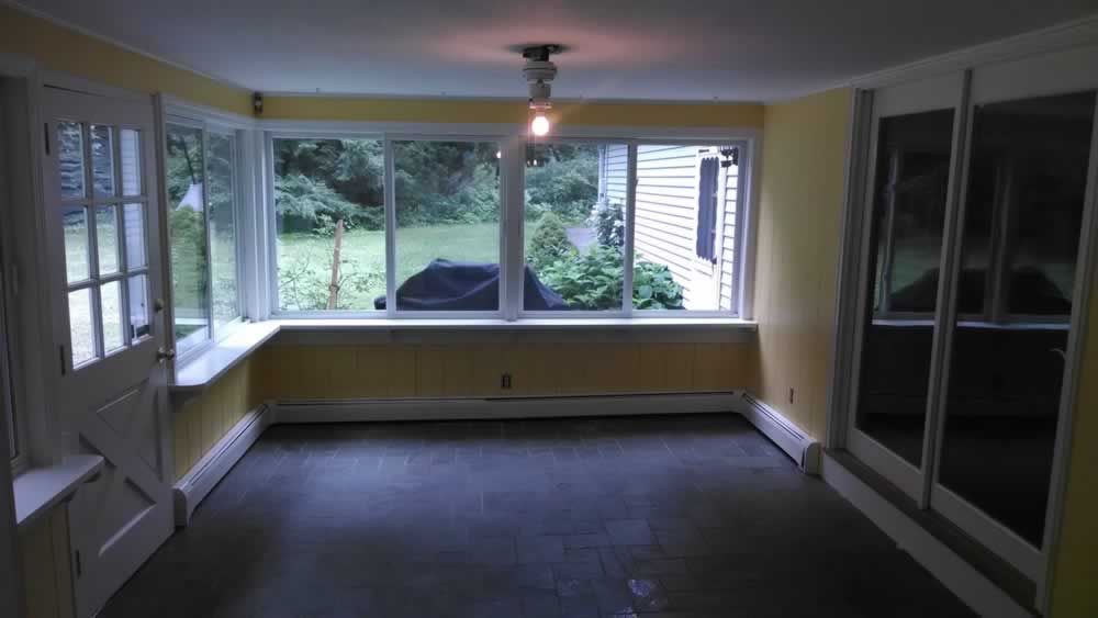 An empty room with yellow walls and sliding glass doors