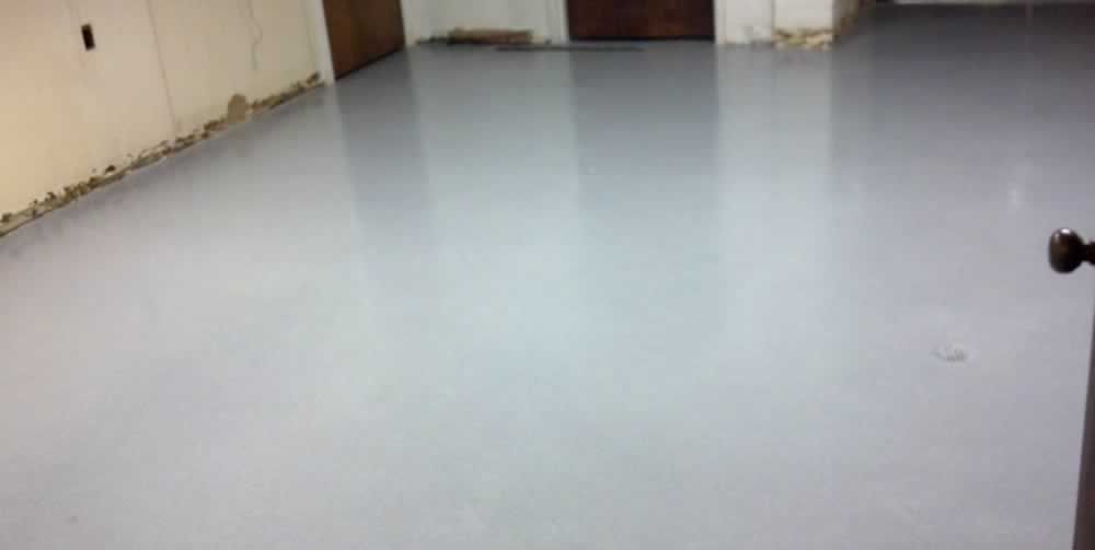 A room with a gray floor and a door.