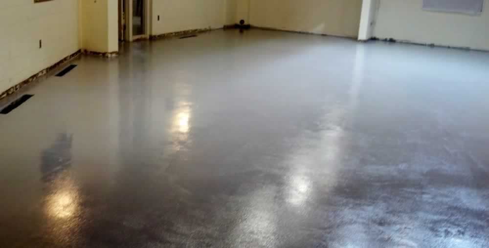 A large room with a shiny concrete floor and white walls.