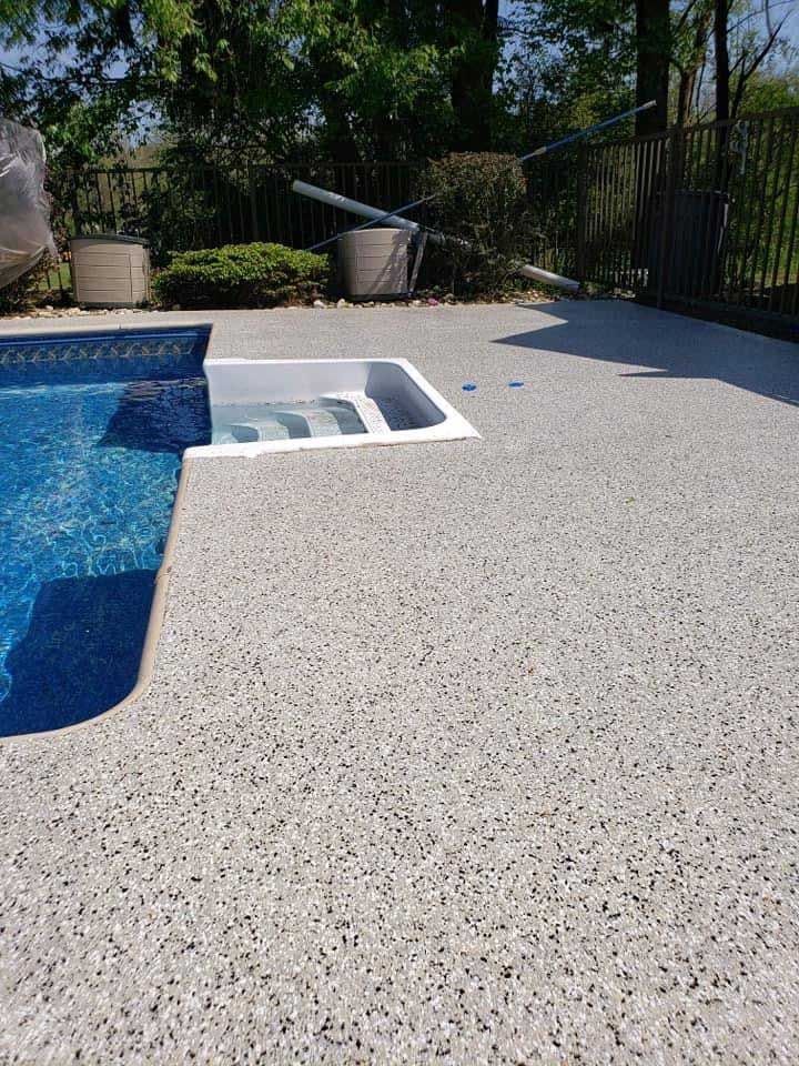 A swimming pool with a concrete deck next to it.
