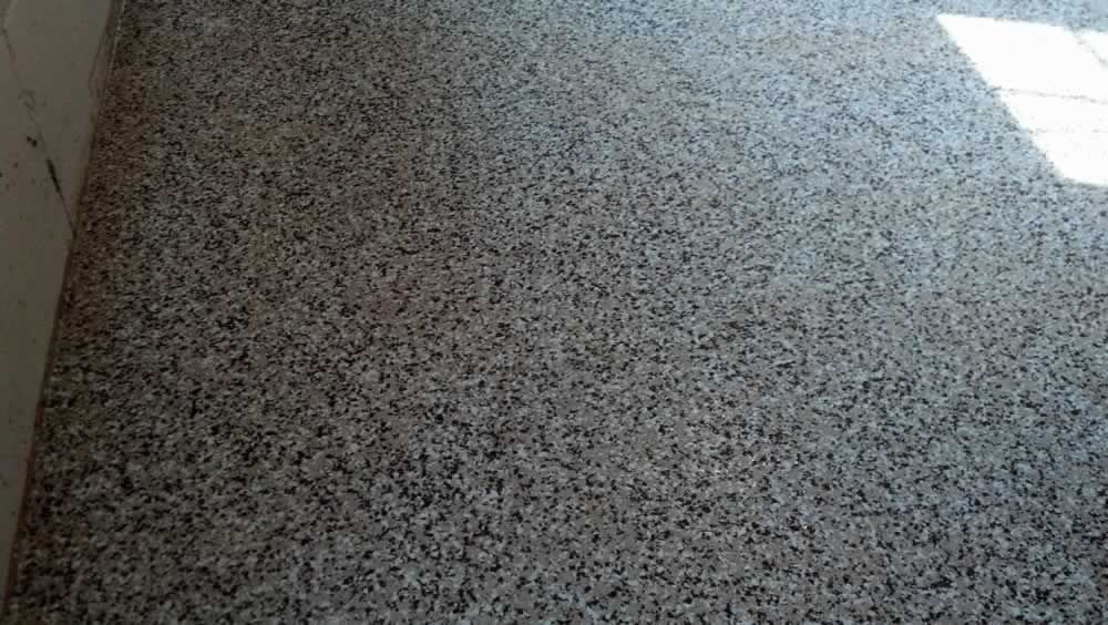 A close up of a gray granite floor in a room.