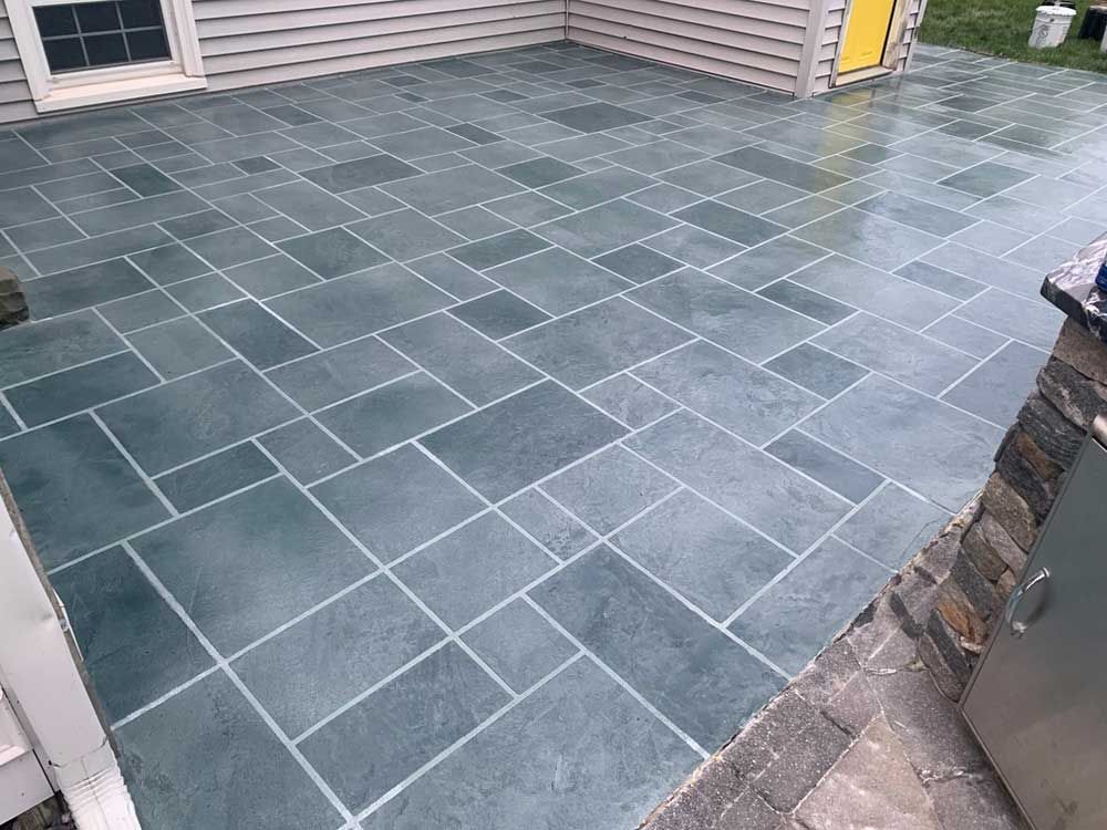 A patio with a blue tile floor and a yellow door.