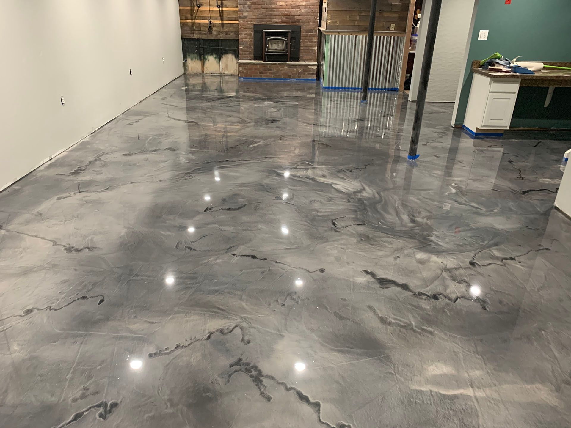 A basement with a marble floor and a fireplace.