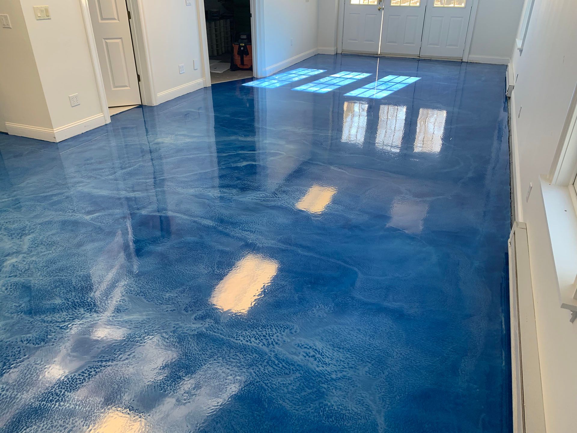 A living room with a blue metallic floor and white walls.