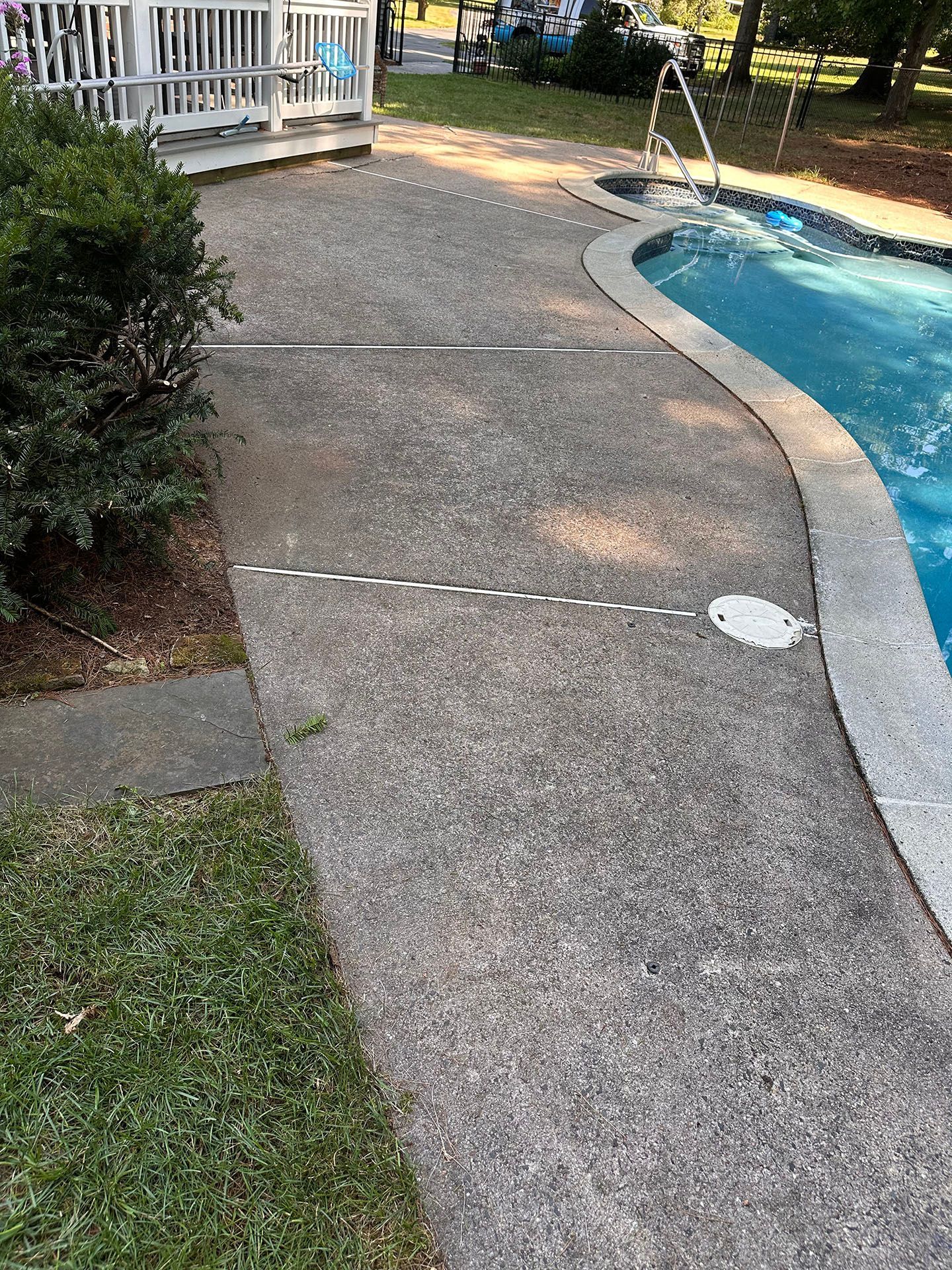 A concrete walkway leading to a swimming pool.