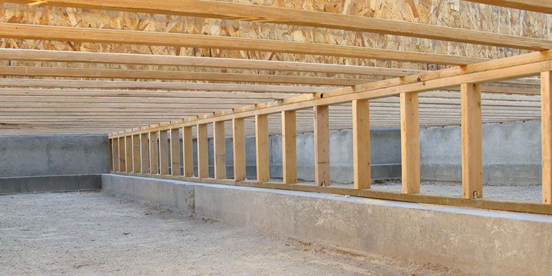 Wooden framing of a low interior platform under construction in an unfinished building