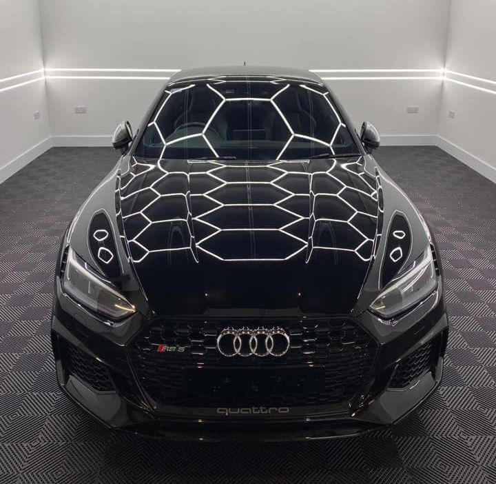 A black audi car is parked in a garage