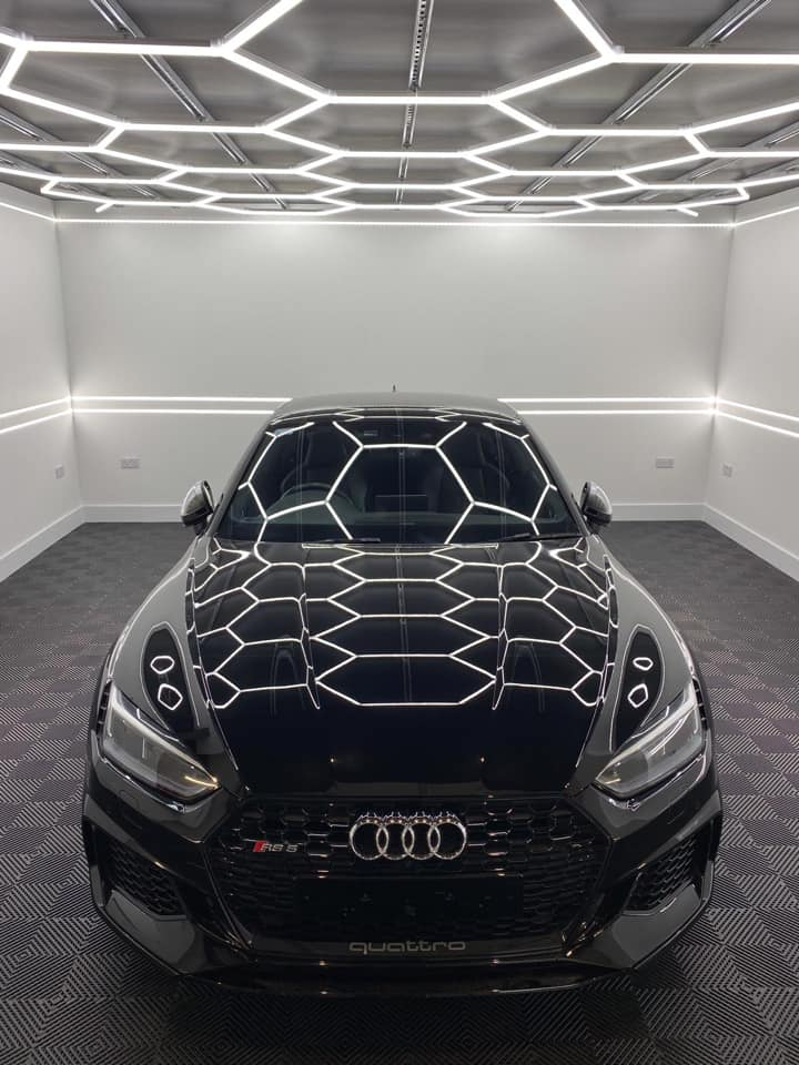 A black audi is parked in a garage.