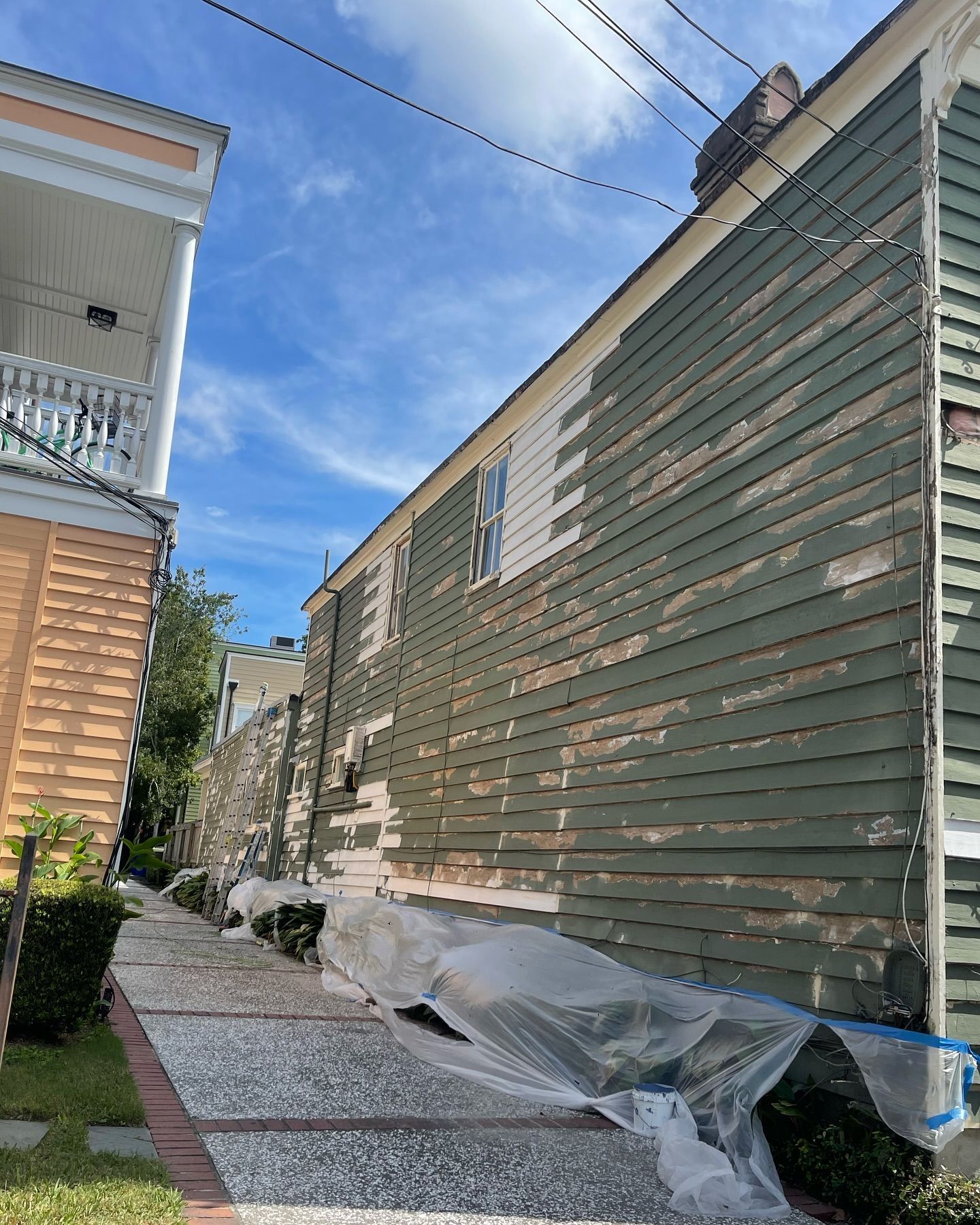 The side of a house is being painted green.