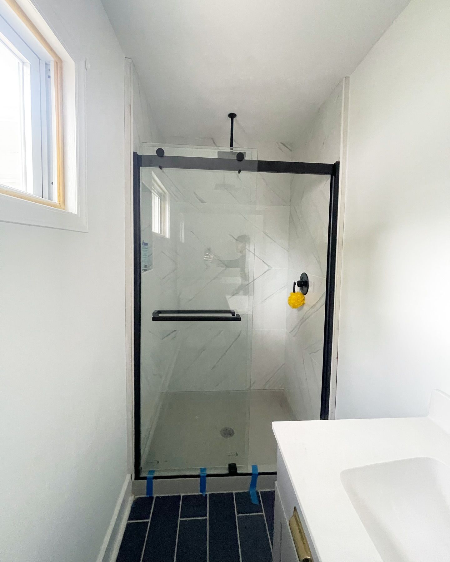 A bathroom with a sliding glass shower door and a sink.