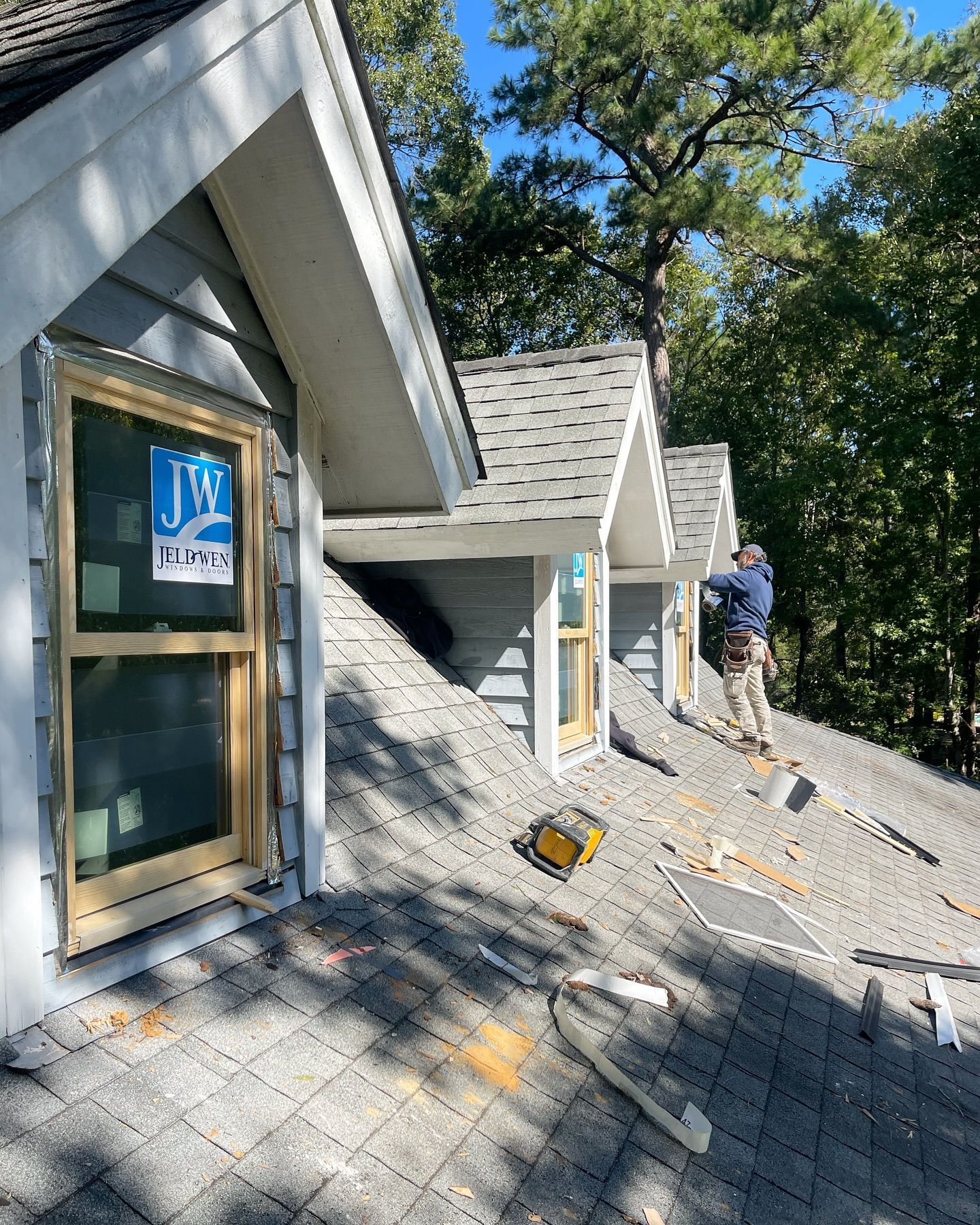 A man is working on the roof of a house.