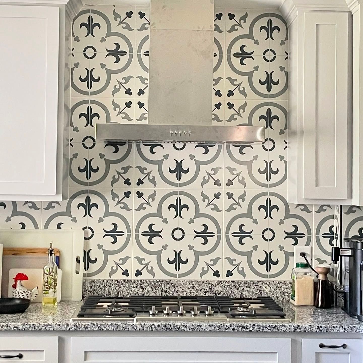 A kitchen with a stove top oven and a stainless steel hood.