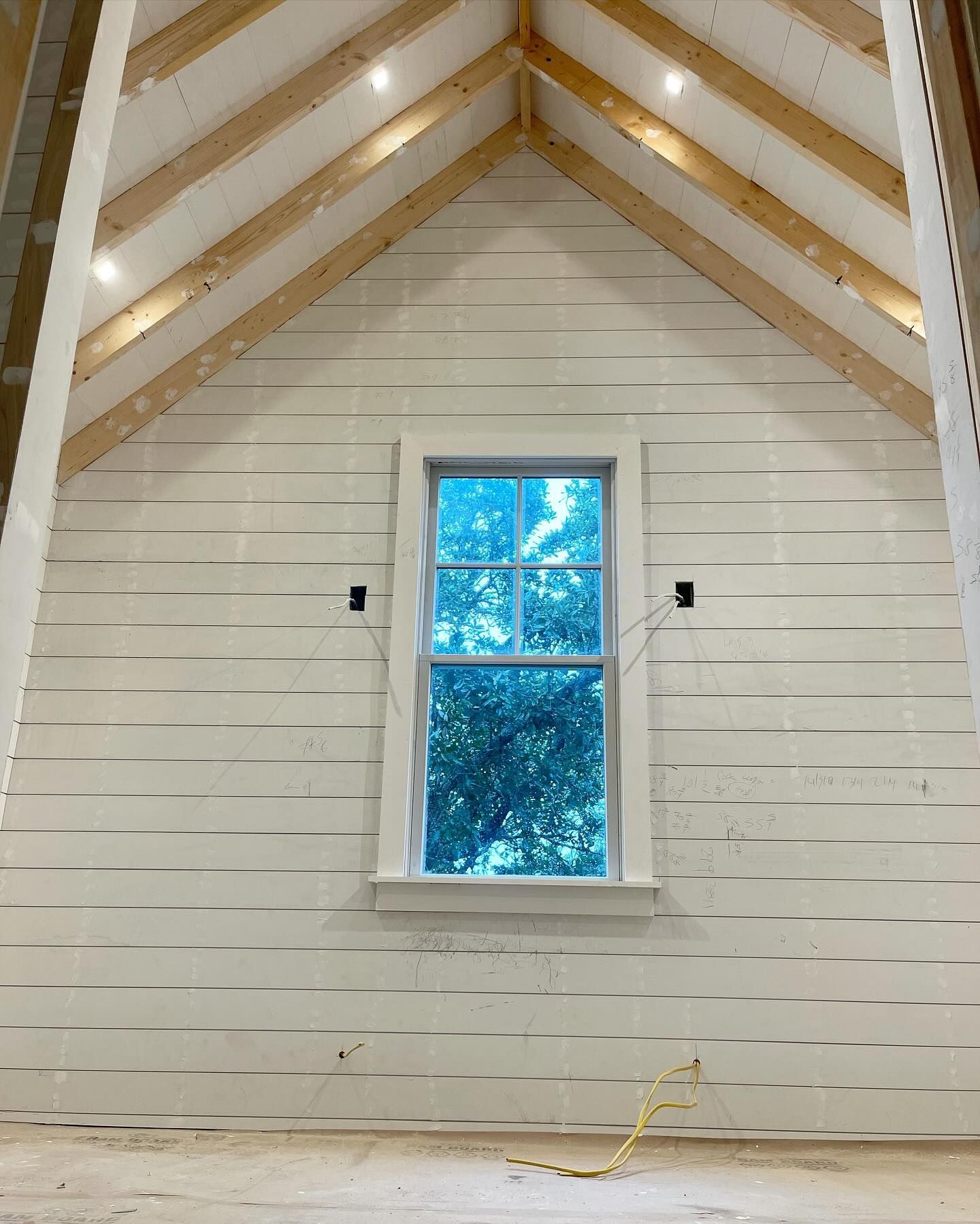 A white wall with a window and a wooden ceiling