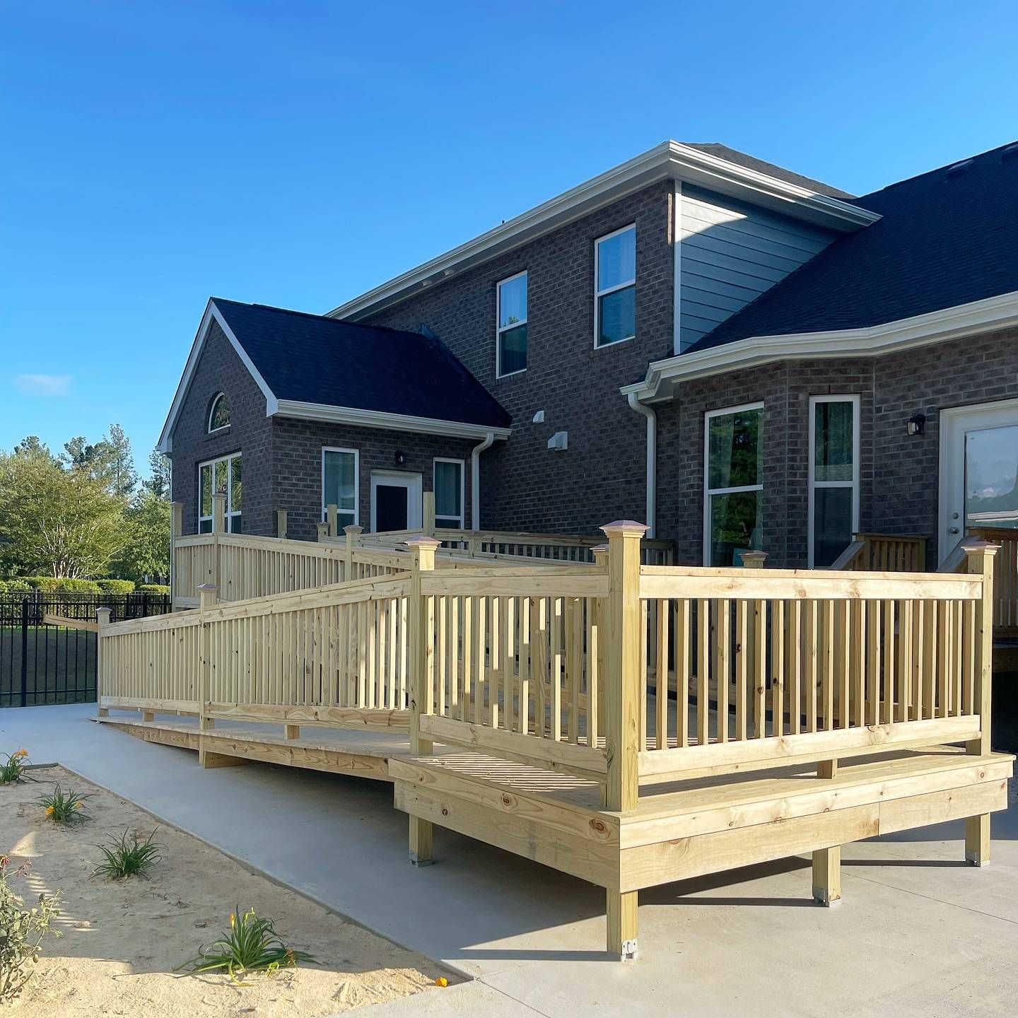 A large brick house with a wooden deck and ramp