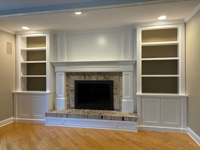 Brick Fireplace with white Cabinets around.