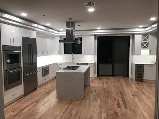 a kitchen with white cabinets and stainless steel appliances