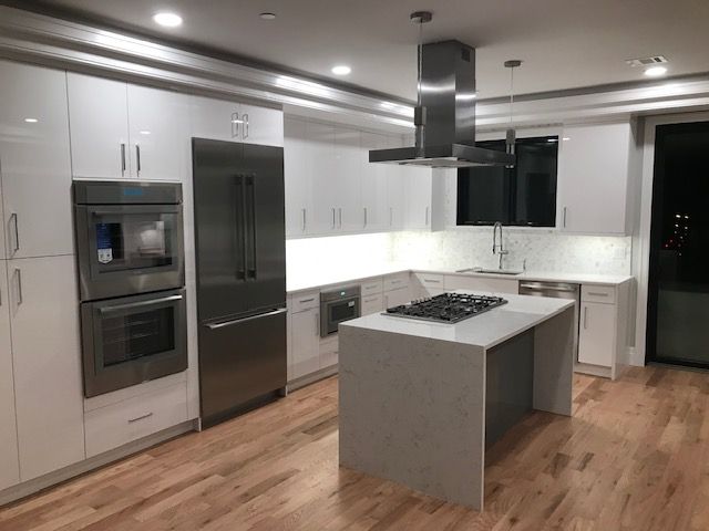 a kitchen with white cabinets and stainless steel appliances