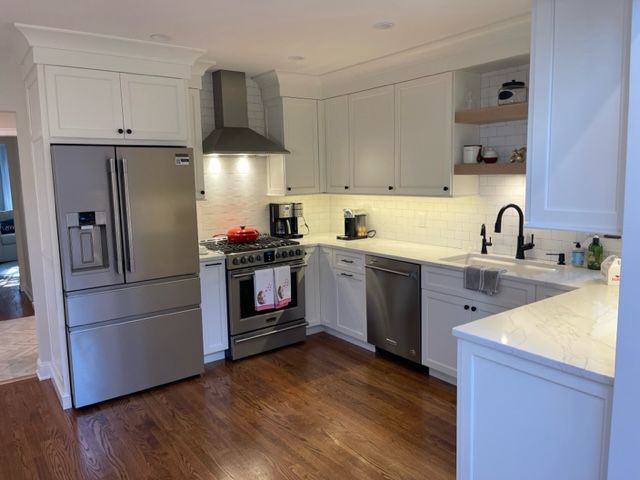 A kitchen with white cabinets and stainless steel appliances.