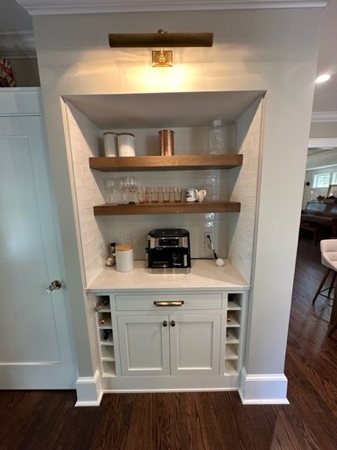 There is a coffee maker on the shelf in the kitchen.