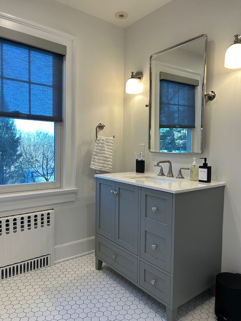 A bathroom with a sink a mirror and a window