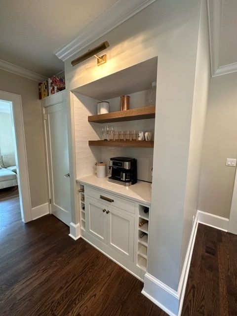 A kitchen with a coffee maker and a wine rack