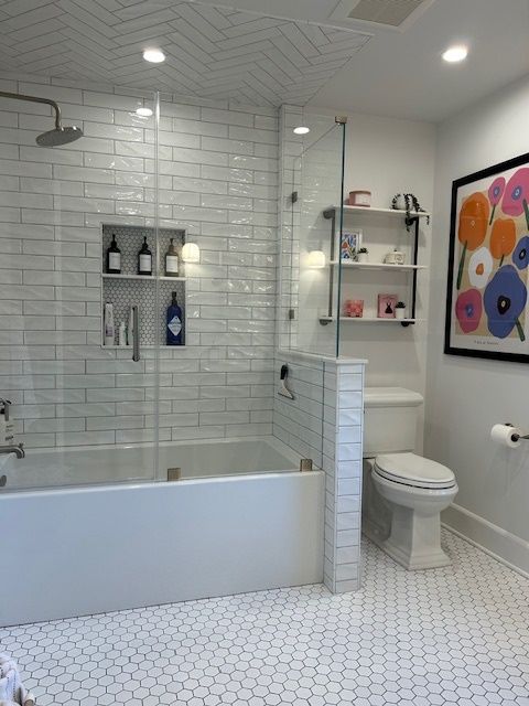 A bathroom with white tiles and a picture of flowers on the wall