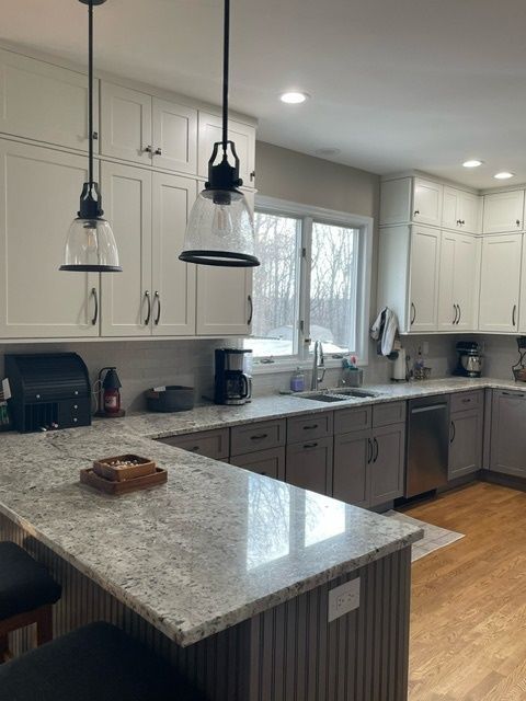 A kitchen with white cabinets and granite counter tops
