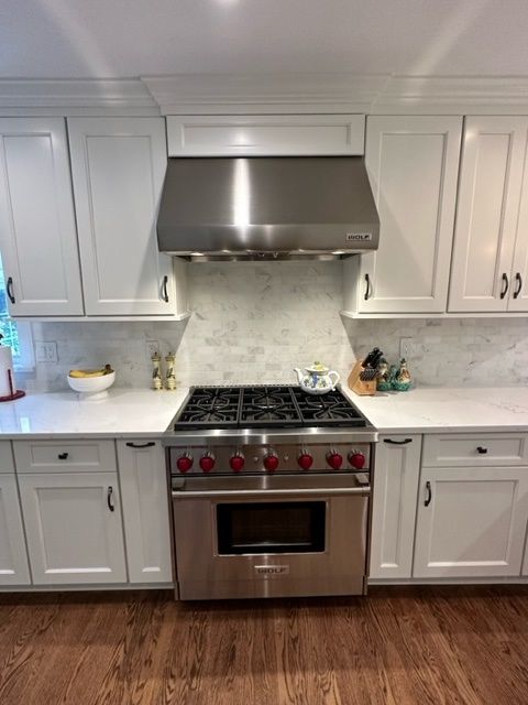 A kitchen with stainless steel appliances and white cabinets