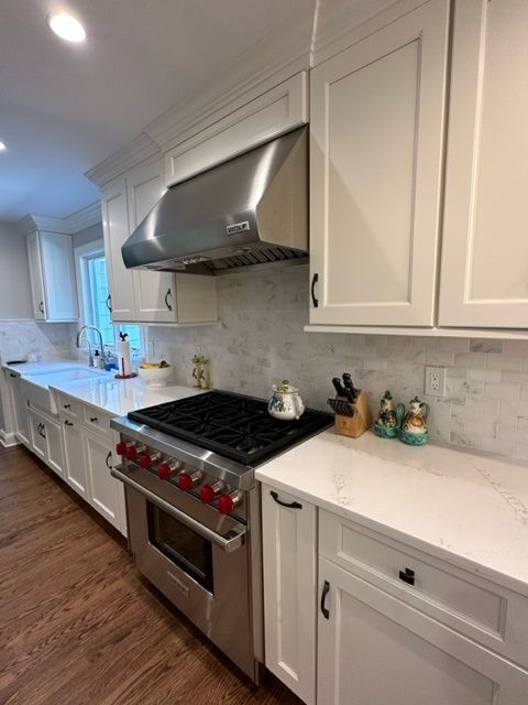 A kitchen with white cabinets and stainless steel appliances.