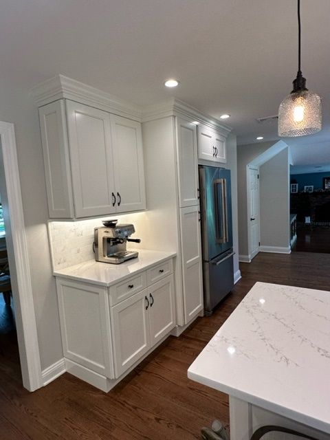 A kitchen with white cabinets and a coffee maker on the counter.