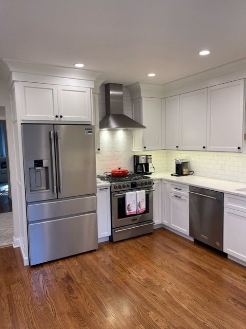 A kitchen with stainless steel appliances and white cabinets