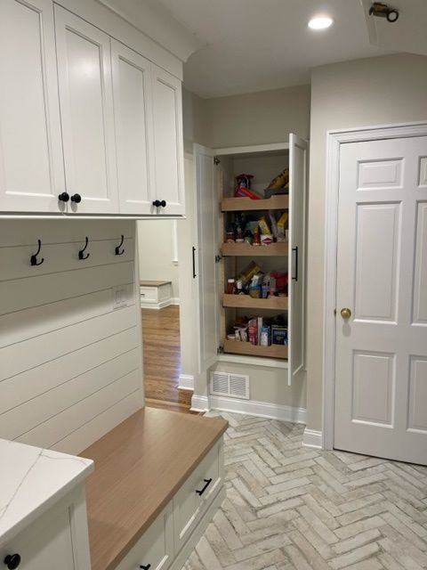A kitchen with white cabinets and a pantry