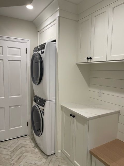 A laundry room with a washer and dryer stacked on top of each other.
