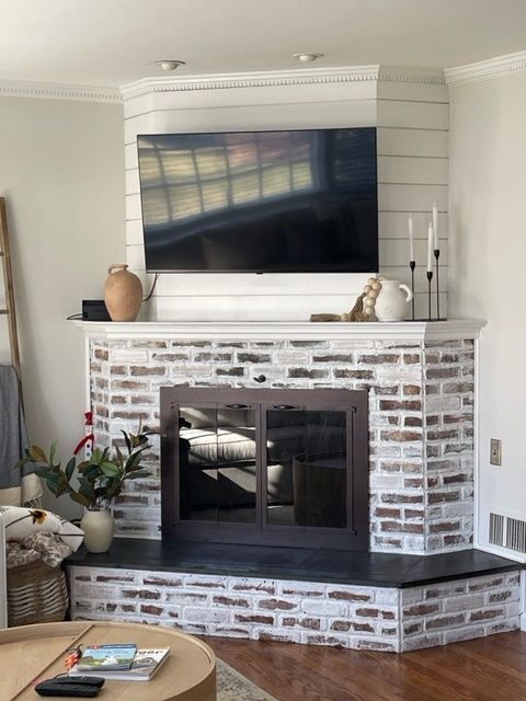 A living room with a fireplace and a flat screen tv