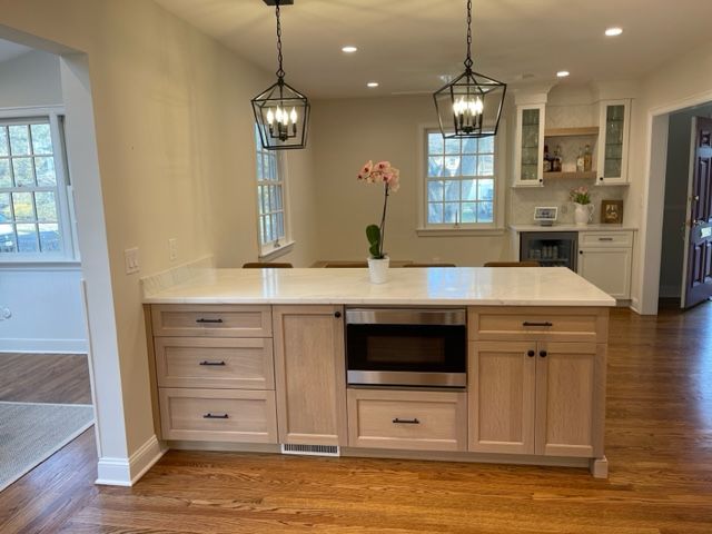 A kitchen with a large island and a microwave oven