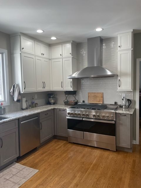 A kitchen with stainless steel appliances and white cabinets
