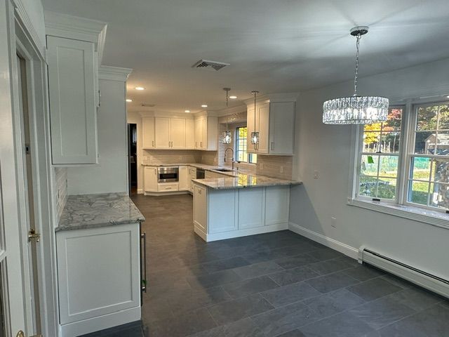 A kitchen with black cabinets and white counter tops