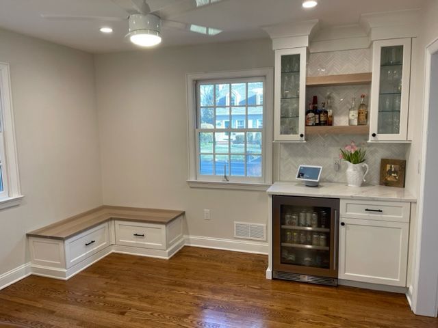 A kitchen with white cabinets and a stainless steel refrigerator