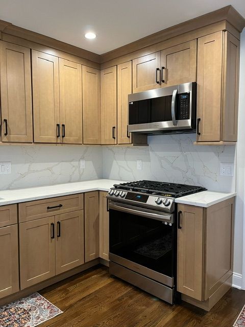 Kitchen counters and cabinets with stove and microwave