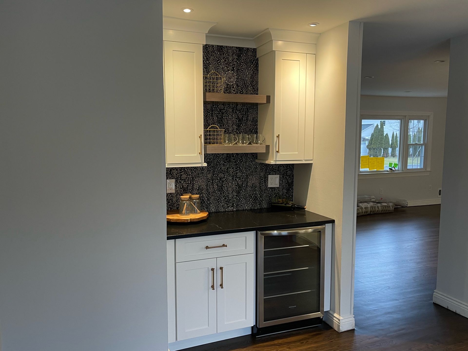 A kitchen with white cabinets and a wine cooler.
