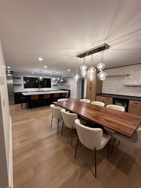 A dining room with a long wooden table and chairs