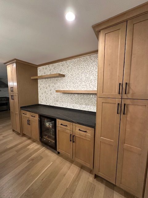 A kitchen with wooden cabinets and a black counter top
